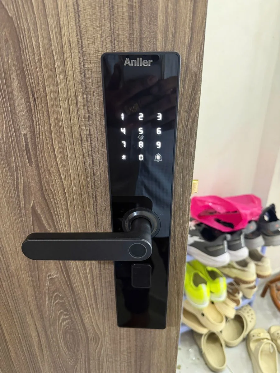 Khóa vân tay Anller mặt kính đen trên cửa gỗ vân xám