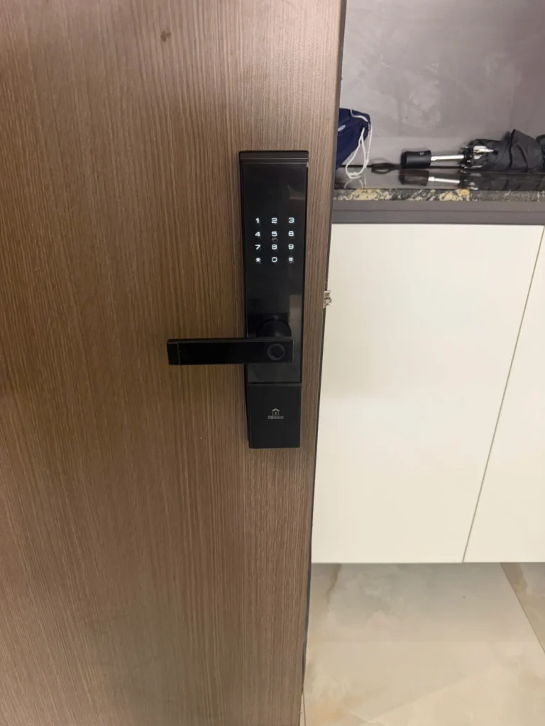 Khóa mã số mặt đen trên cửa gỗ, bàn phím đang sáng